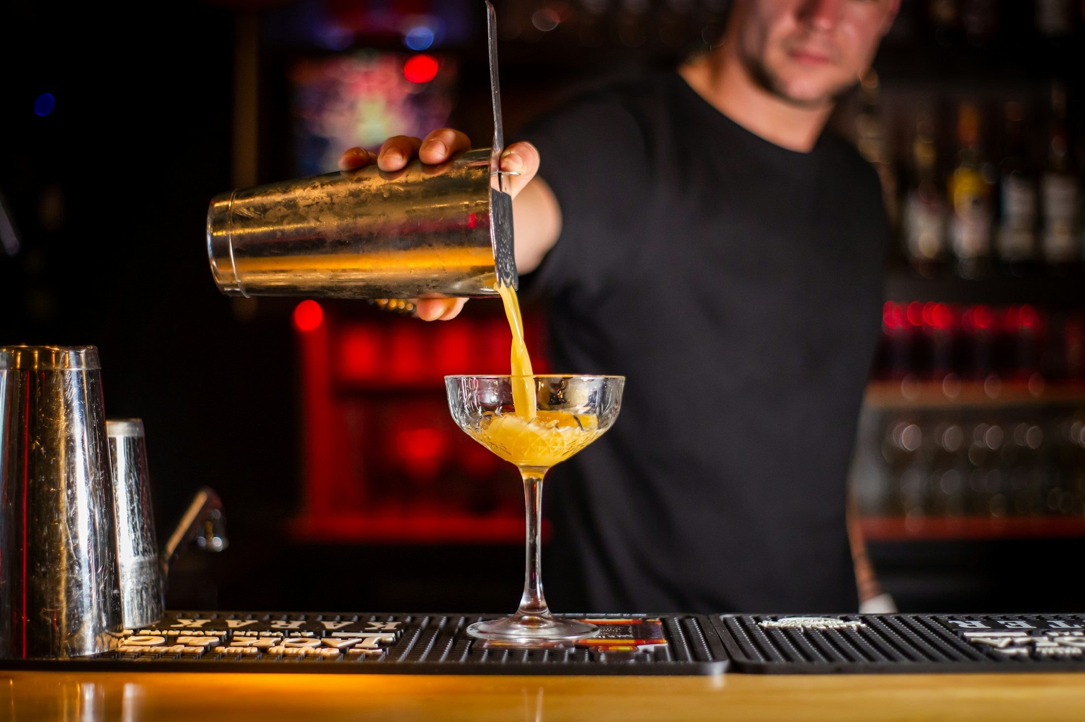 Bartender sirviendo un cóctel en una copa