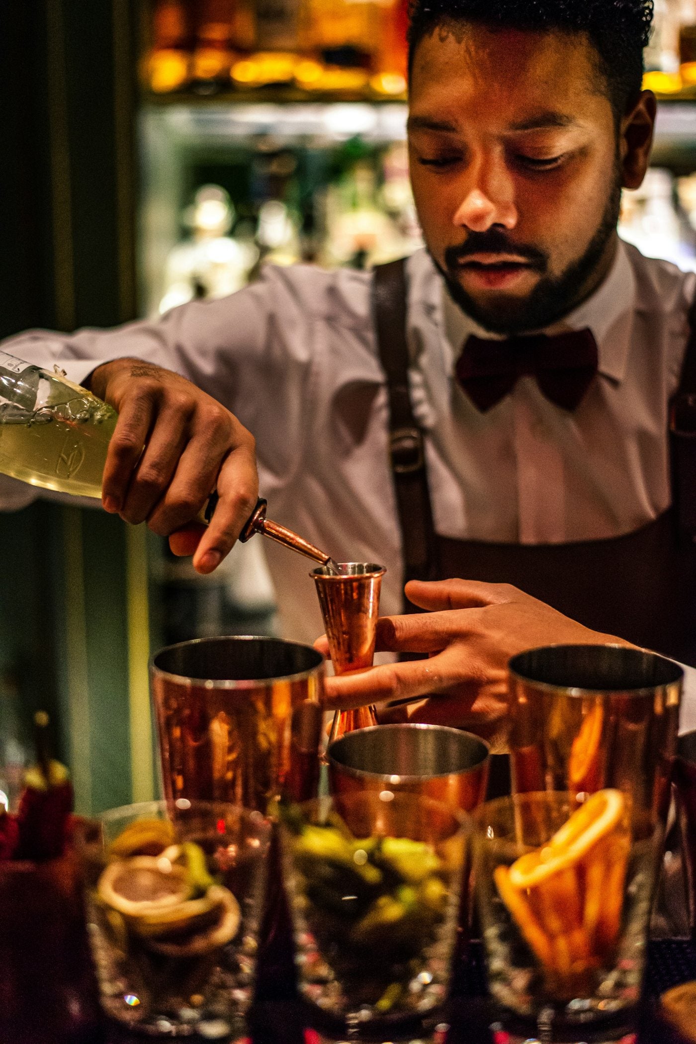 Bartender midiendo ingredientes para preparar un cóctel